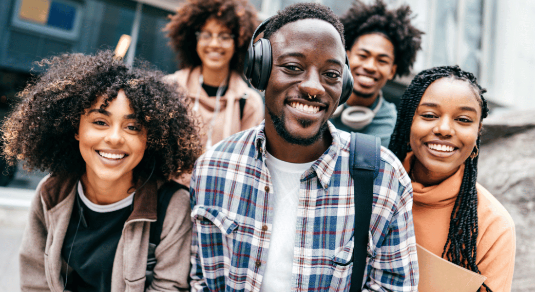 5 college students excited to be in front of the camera, college building on the background